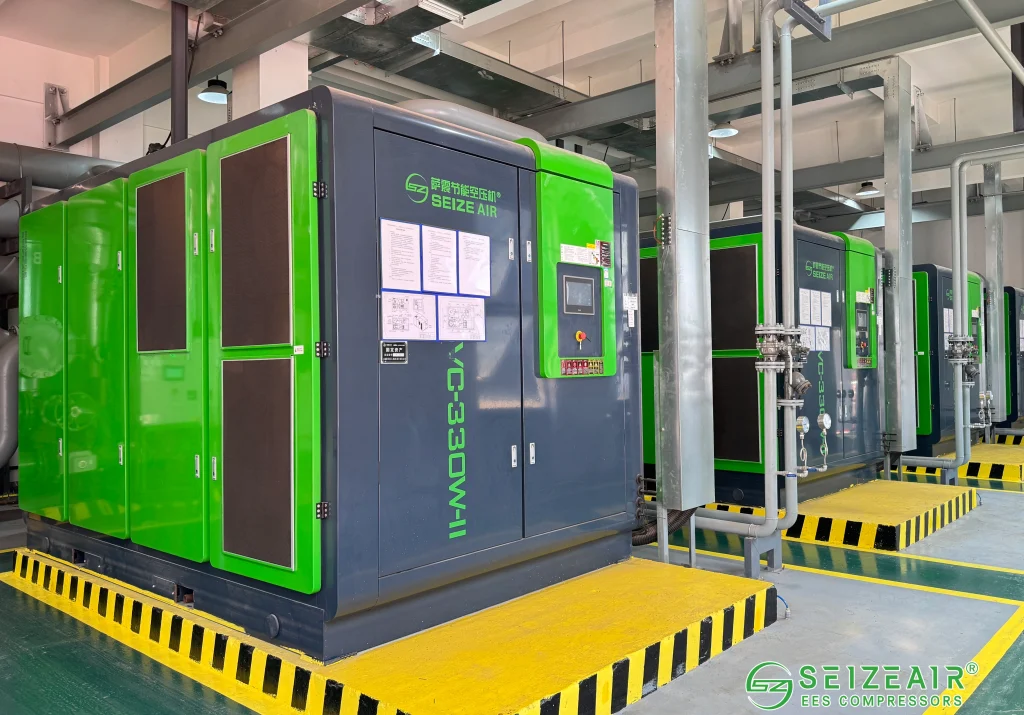 Industrial screw air compressor powering pneumatic tools in a factory workshop