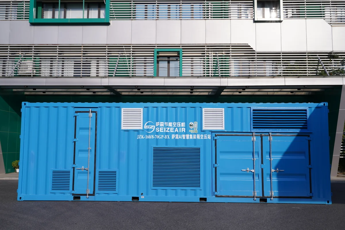 Blue containerized skid mounted air compressor station standing outdoors with ventilation louvres and access doors